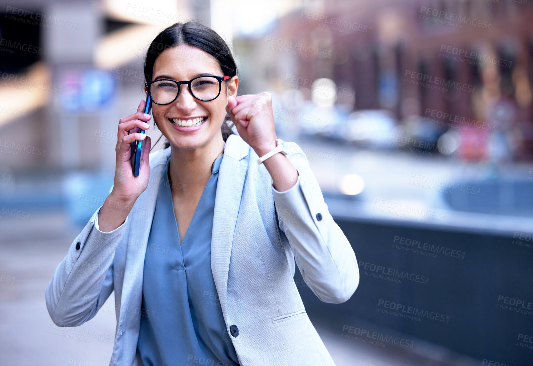 Buy stock photo Shot of a young businesswoman cheering in happiness during a phone call