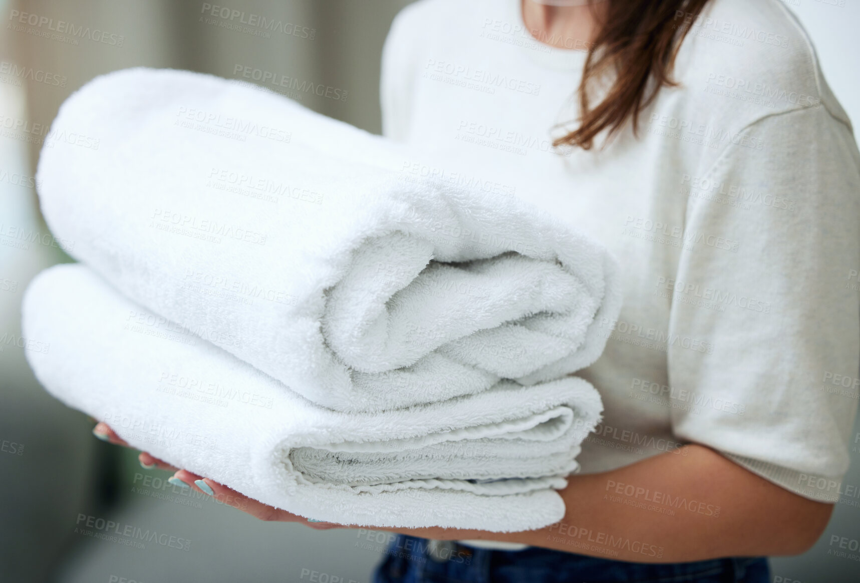 Buy stock photo Shot of an unrecognizable woman folding towels at home