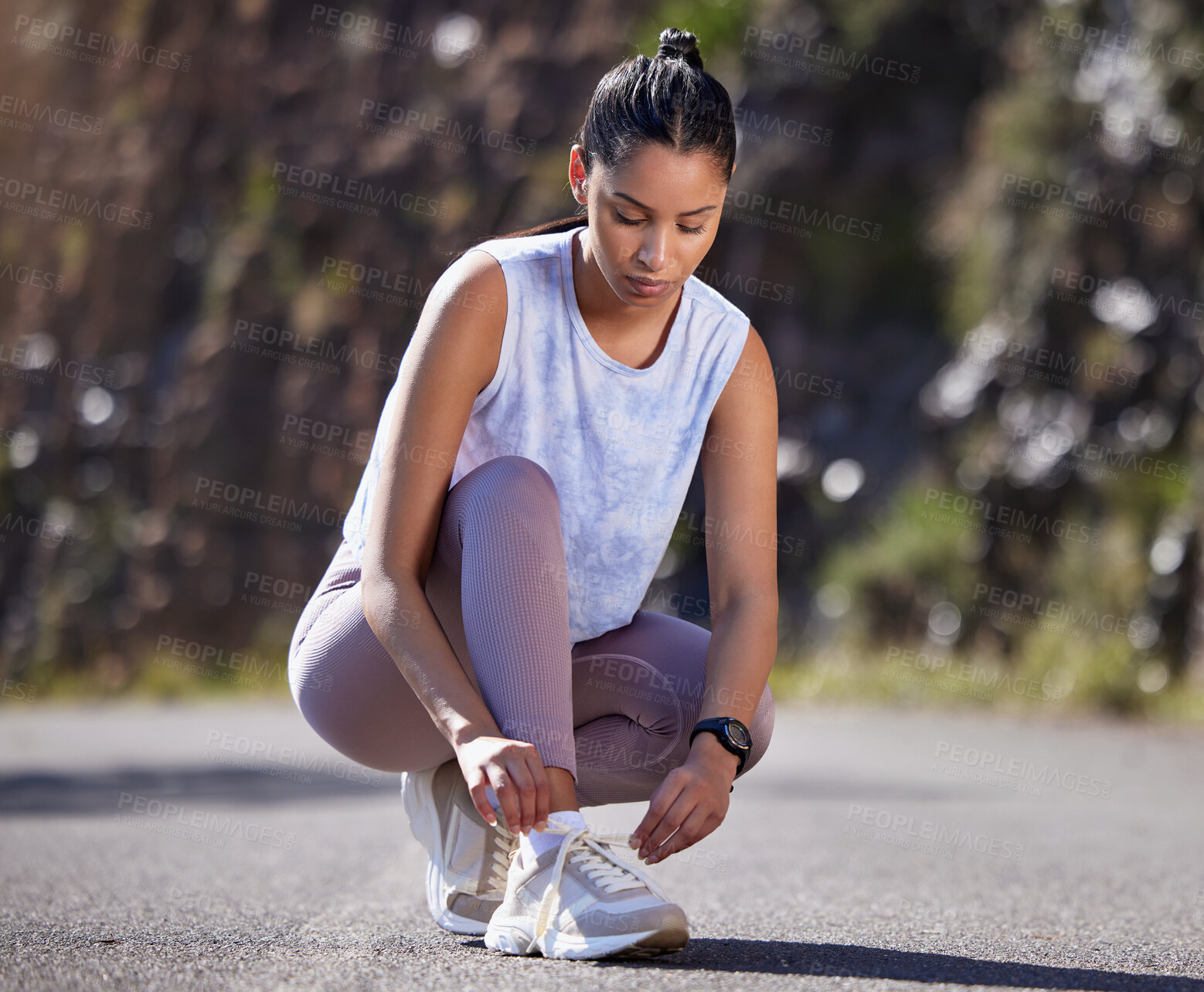 Buy stock photo Full length shot of an attractive young female athlete tying her laces while out for a run