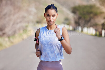 Buy stock photo Cropped portrait of an attractive young female athlete enjoying a run outdoors