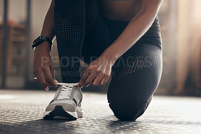 Buy stock photo Fitness, woman and tying shoes in gym ready for workout, exercise and training for physical strength. Female person, sneakers and hands fixing laces on ground, floor and girl prepare for sports