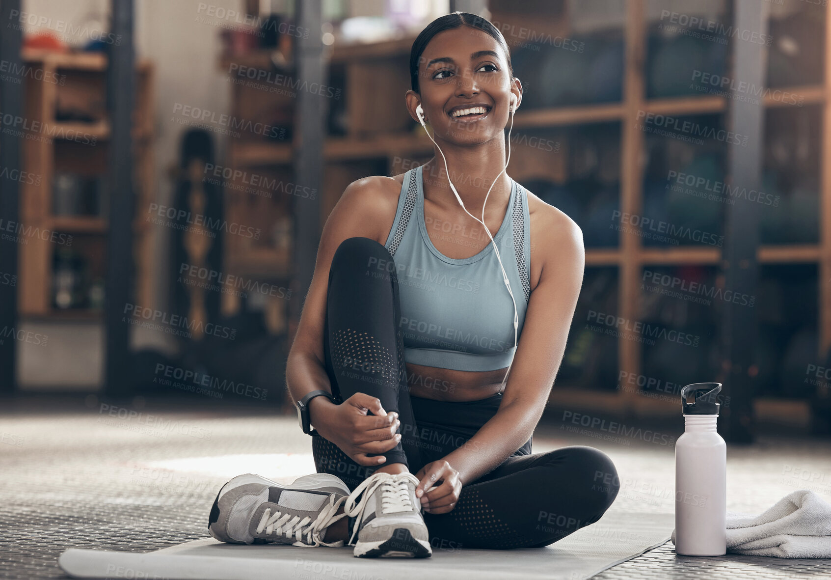 Buy stock photo Woman in gym, relax with earphones and fitness, workout and listening to music with smile and sports. Healthy, active with happy Indian female sitting in exercise studio and music for motivation