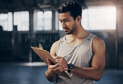 Buy stock photo Sports, clipboard and male personal trainer in the gym working on a training schedule checklist. Young, confident and man athlete coach writing workout or exercise plan for wellness in fitness center