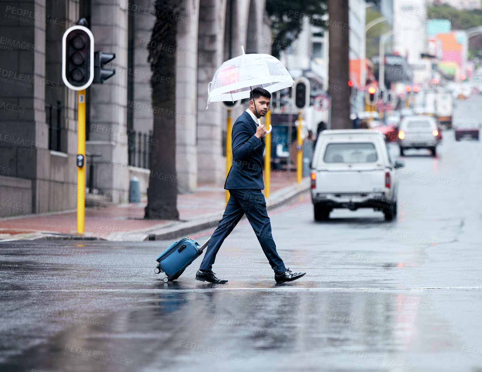 Buy stock photo Businessman, walking and city with umbrella on street for travel, work or business trip in winter. Man, employee or pedestrian crossing road with luggage for commute or immigration in an urban town