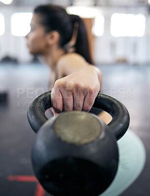 Buy stock photo Shot of a young woman working out with kettle bell weights in a gym