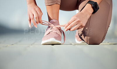 Buy stock photo Closeup shot of an unrecognisable woman tying her laces while exercising outdoors