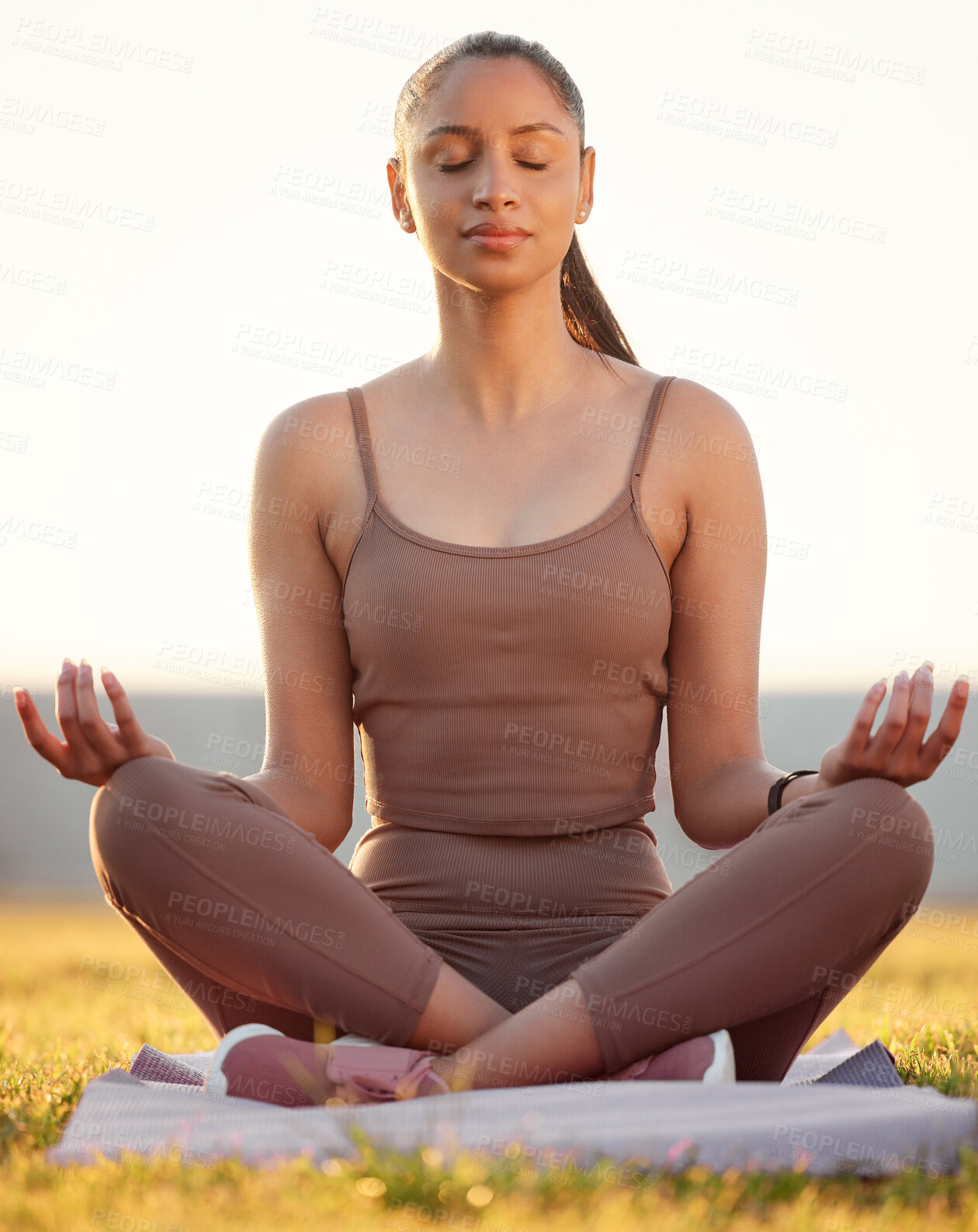 Buy stock photo Shot of a sporty young woman meditating while exercising outdoors