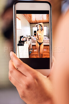 Buy stock photo Shot of a young woman taking a topless selfie