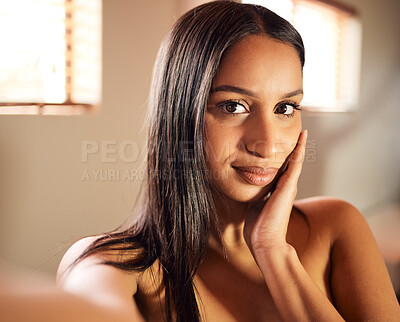 Buy stock photo Shot of a young woman taking a topless selfie