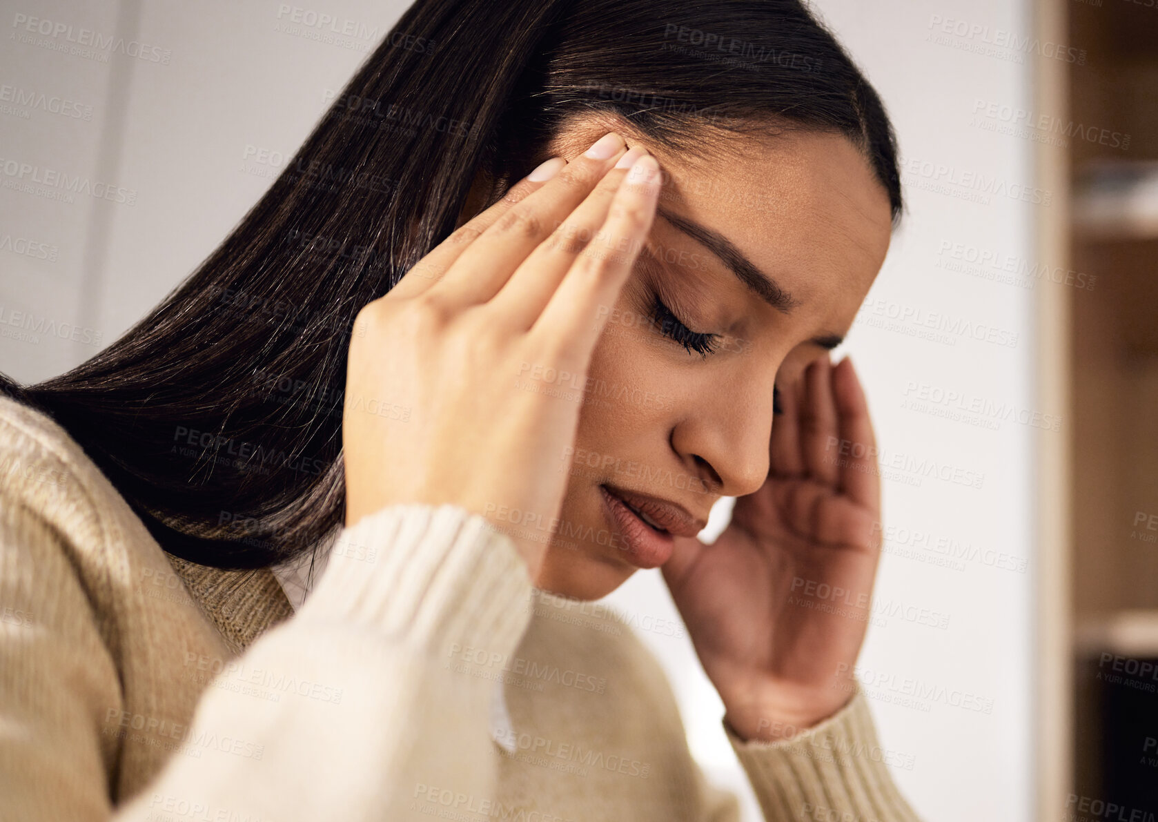 Buy stock photo Shot of a beautiful young woman looking stressed while sitting at home