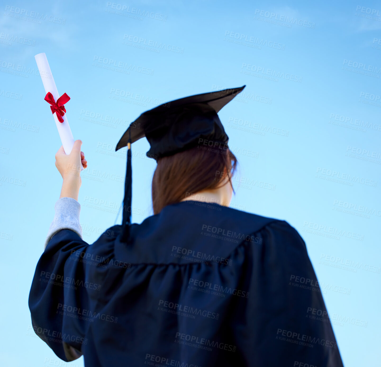 Buy stock photo Woman, celebration and diploma at outdoor graduation ceremony, blue sky and proud of education. Female person, back and degree at college or university for achievement, graduate and learning award