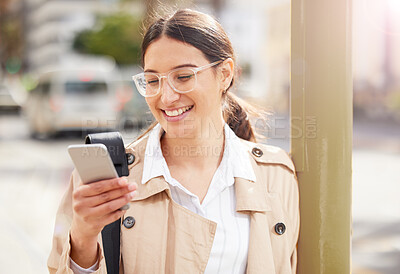 Buy stock photo Shot of a young woman using a smartphone while out in the city