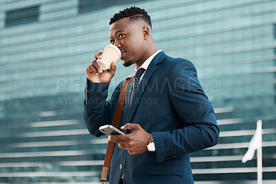 Buy stock photo Shot of a young businessman drinking coffee while using his smartphone