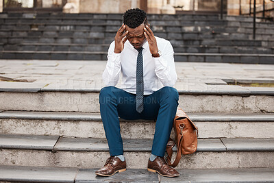 Buy stock photo Shot of a young businessman clutching his head in pain