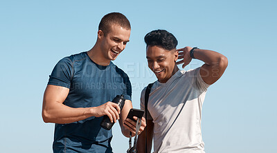 Buy stock photo Shot of two young men using a smartphone before going for a swim