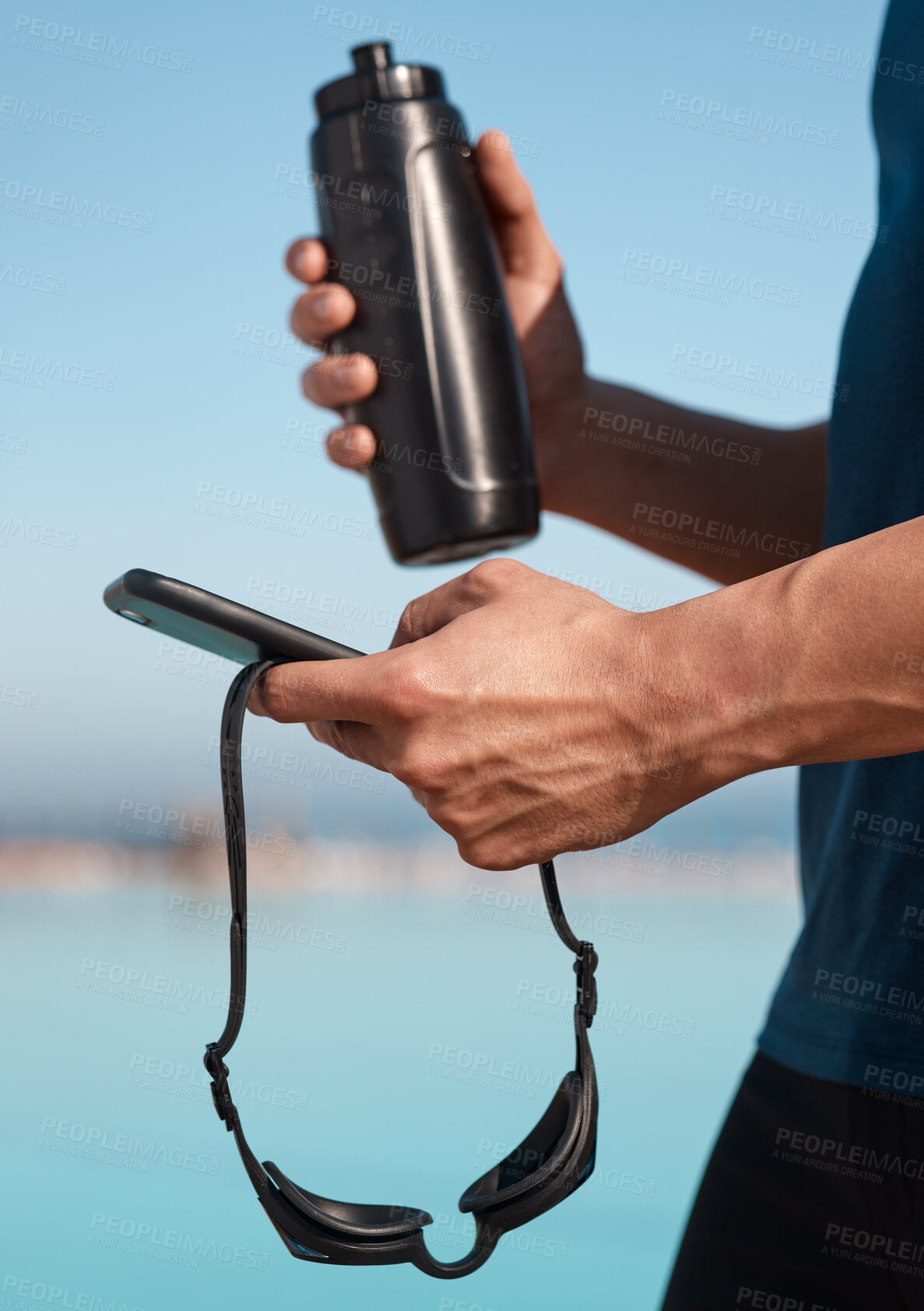 Buy stock photo Shot of an unrecognisable man using a smartphone before going for a swim