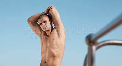 Buy stock photo Shot of a young man stretching before going for a swim