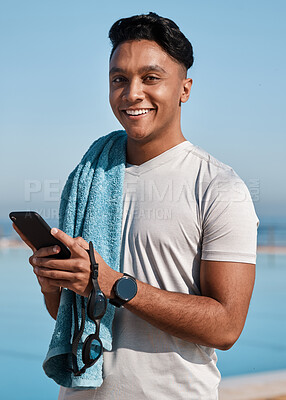 Buy stock photo Shot of a young man using a smartphone before going for a swim