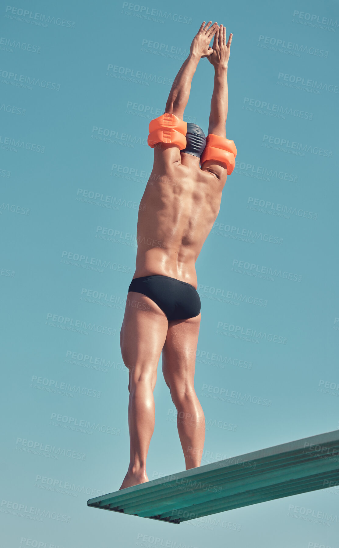 Buy stock photo Rearview shot of an unrecognizable male athlete standing on a diving board outside