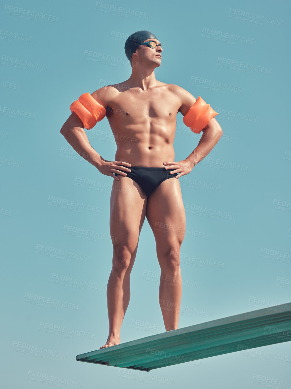 Buy stock photo Full length shot of a handsome young male athlete standing on a diving board outside