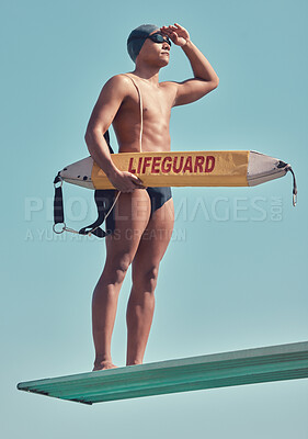 Buy stock photo Full length shot of a handsome young male lifeguard standing on a diving board outside