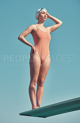 Buy stock photo Full length shot of an attractive young female athlete standing on a diving board outside