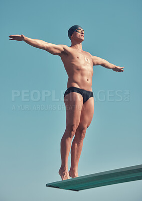 Buy stock photo Full length shot of a handsome young male athlete standing on a diving board outside
