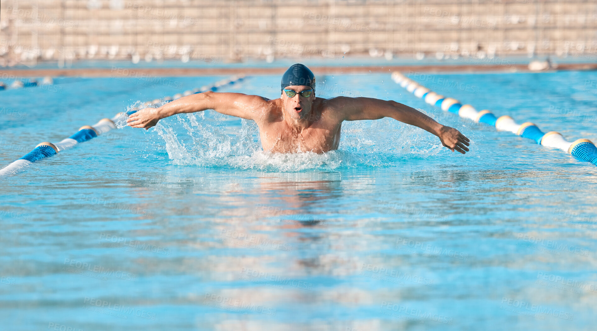 Buy stock photo Shot of a handsome young male athlete swimming in an olympic-sized pool