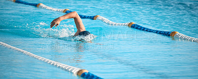 Buy stock photo Shot of an unrecognizable young male athlete swimming in an olympic-sized pool