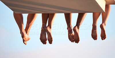 Buy stock photo Rearview shot of three unrecognizable swimmers sitting on a diving board