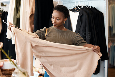 Buy stock photo Shot of a beautiful young woman shopping for clothing at her favourite boutique