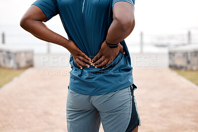 Buy stock photo Man, fitness and back pain after workout, cardio exercise or running and training outdoors. Rear view of male person, athlete or runner with sore spine, injury or ache and bone inflammation in nature