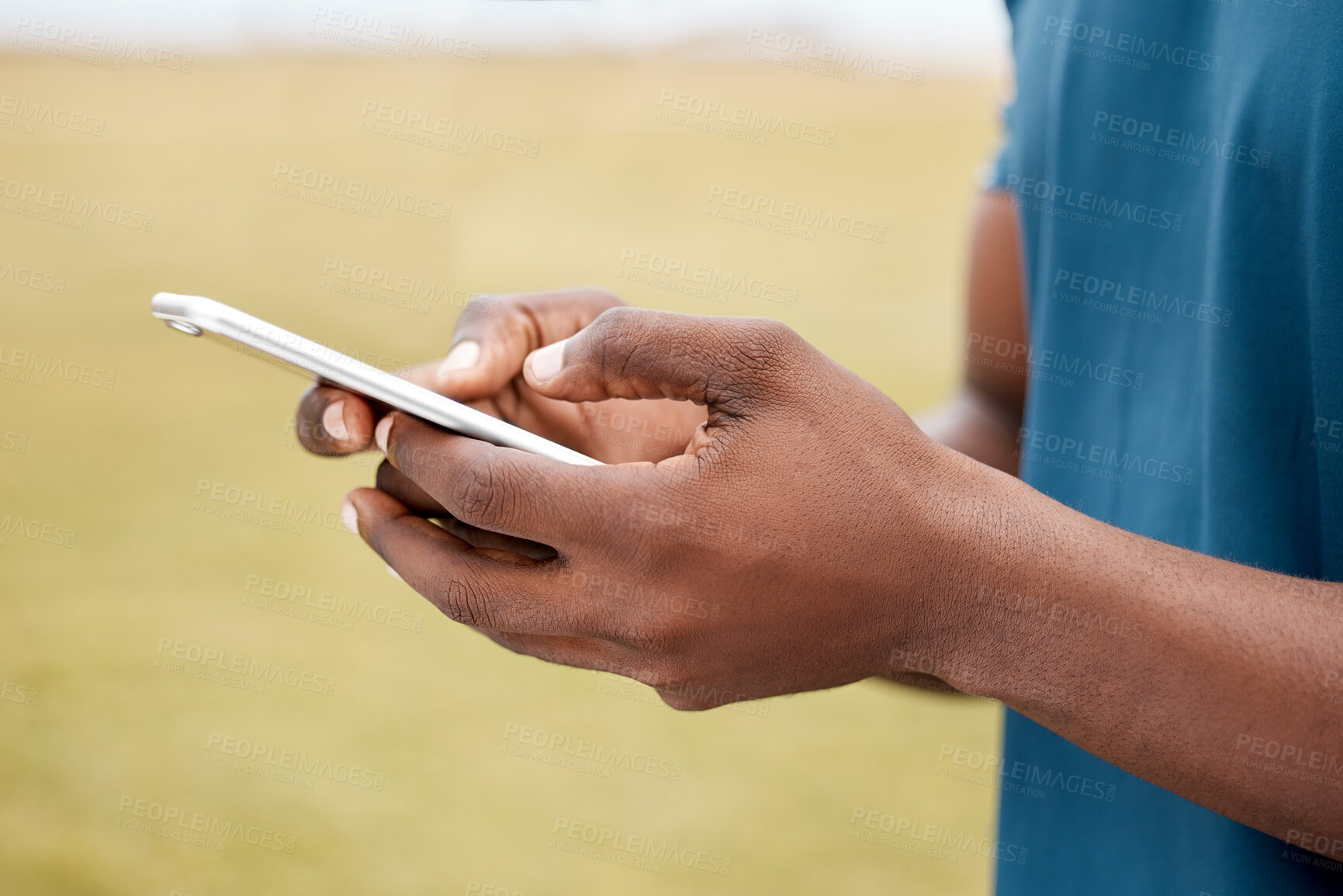 Buy stock photo Man, hands and phone for social media, communication or networking in sports on grass field outdoors. Hand of male person or athlete chatting, typing or texting on mobile smartphone app in nature