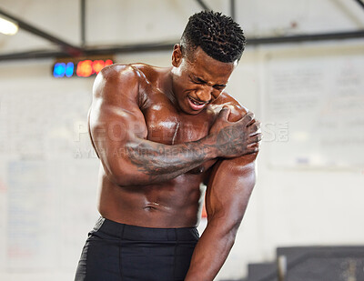 Buy stock photo African man, gym and shoulder injury in pain with fitness, muscular and exercise at workout. Bodybuilder, hurt and holding arm for torn muscle, burnout and strain in sports or weightlifting