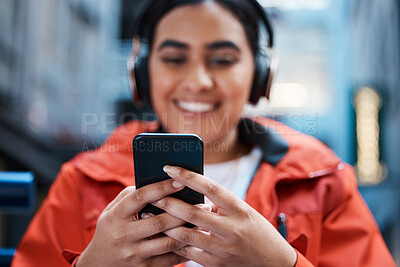 Buy stock photo Woman, hands and smile with headphones for smartphone with texting or streaming for entertainment. Music, movie or educational video with fun in college or home with study, higher education and happy