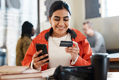 Buy stock photo Shot of a young female student using a phone and credit card at college