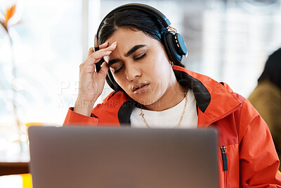 Buy stock photo Shot of a young female student suffering from a headache while studying at college