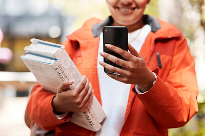 Buy stock photo Shot of an unrecognizable student using a phone while studying at college