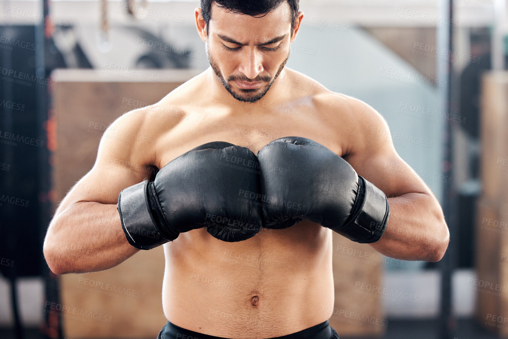 Buy stock photo Shot of a handsome young boxer practicing his jab at gym