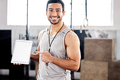 Buy stock photo Shot of a handsome young man using a digital tablet at the gym