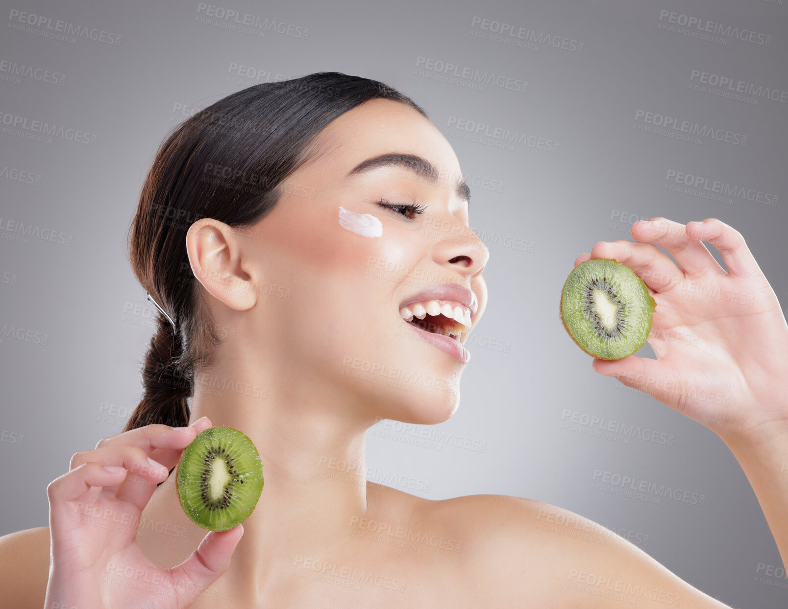 Buy stock photo Kiwi, lotion and face of natural woman in studio on gray background for diet, health or nutrition. Beauty, fruit or skincare and happy model with fresh produce for organic dermatology or detox