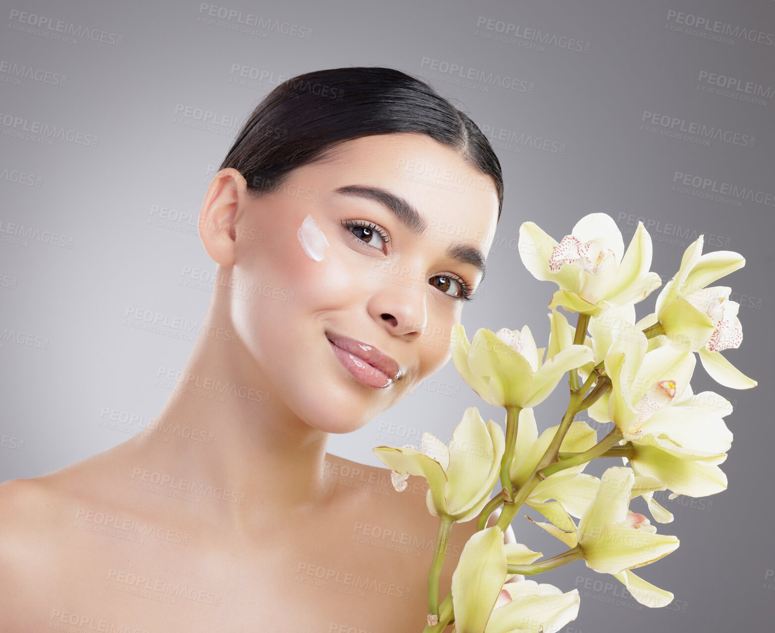 Buy stock photo Woman, portrait and flowers for cream in studio, sunscreen and eco friendly skincare on gray background. Female person, beauty and moisturizer for hydration, orchids and lotion treatment for cosmetic