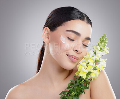 Buy stock photo Studio shot of an attractive young woman posing with a bunch of flowers against a grey background