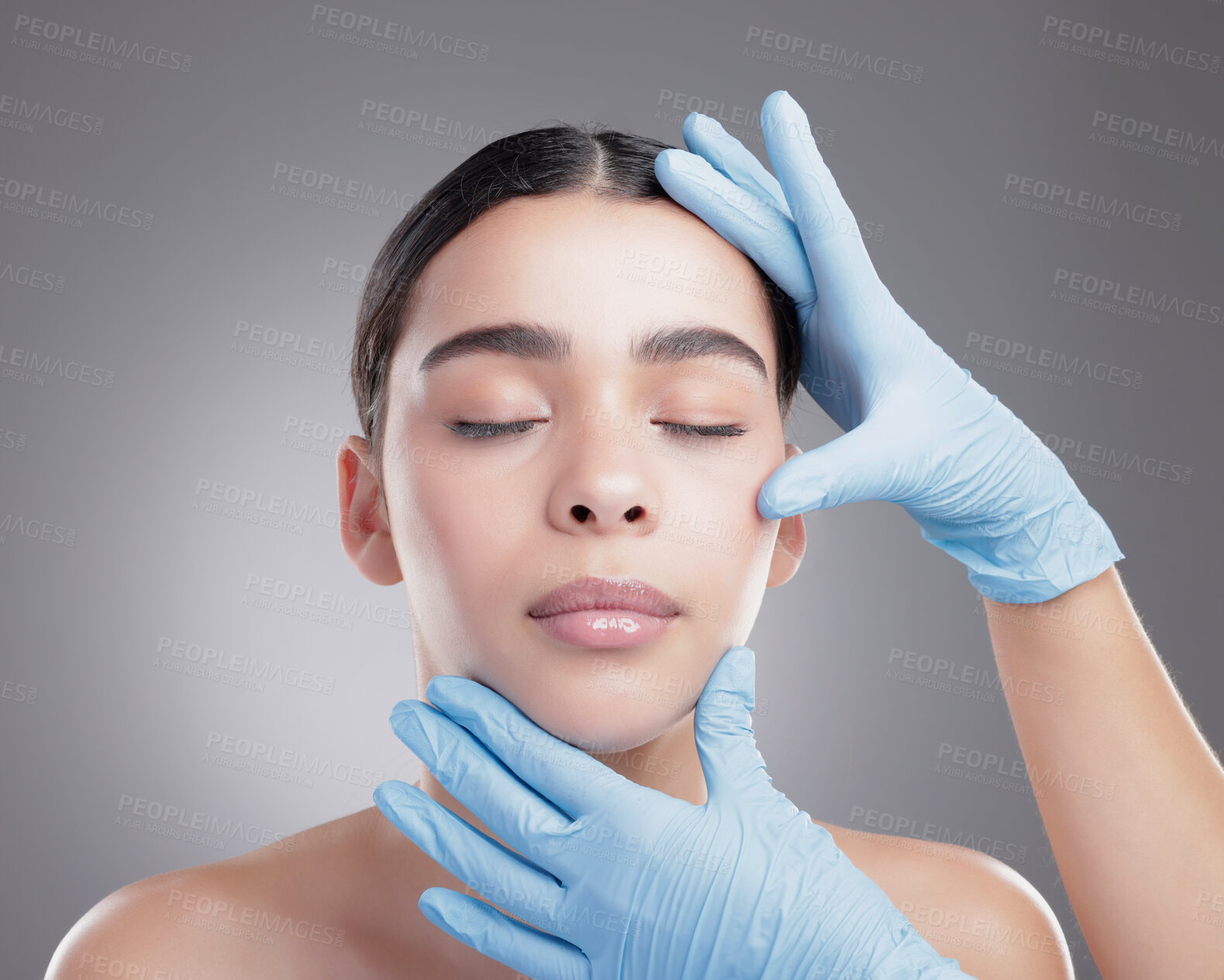 Buy stock photo Studio shot of an attractive young woman having some plastic surgery done against a grey background