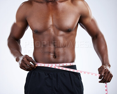 Buy stock photo Studio shot of an unrecognizable musclar man measuring his waist against a grey background