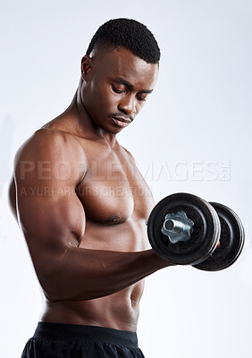 Buy stock photo Studio shot of a handsome young muscular man working out with a dumbbell against a grey background