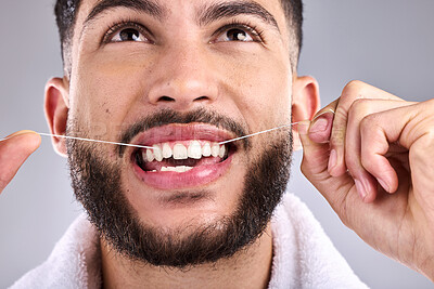 Buy stock photo Face, dental and man floss teeth in studio isolated on a white background. Tooth, flossing product and male model cleaning for oral wellness, fresh breath and healthy hygiene to stop gingivitis.