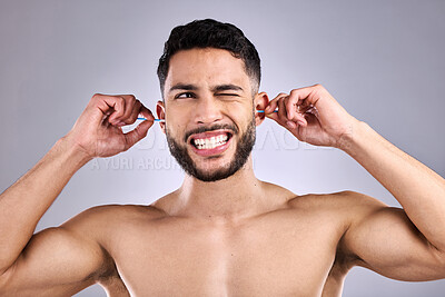 Buy stock photo Man, ear and cleaning for hygiene, hearing and wellness in studio with wax, scratch and pain of infection. Model struggle with cotton bud for cosmetic health, routine or self care on gray background