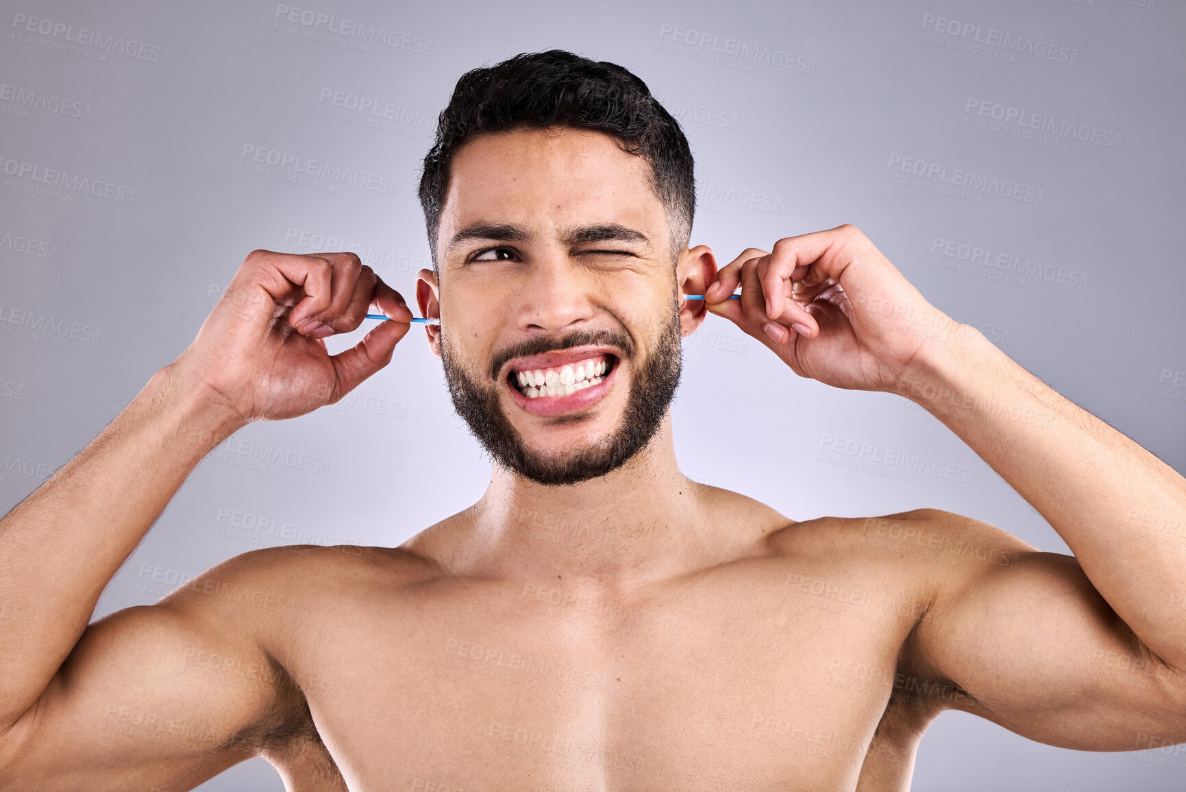 Buy stock photo Man, ear and cleaning for hygiene, hearing and wellness in studio with wax, scratch and pain of infection. Model struggle with cotton bud for cosmetic health, routine or self care on gray background