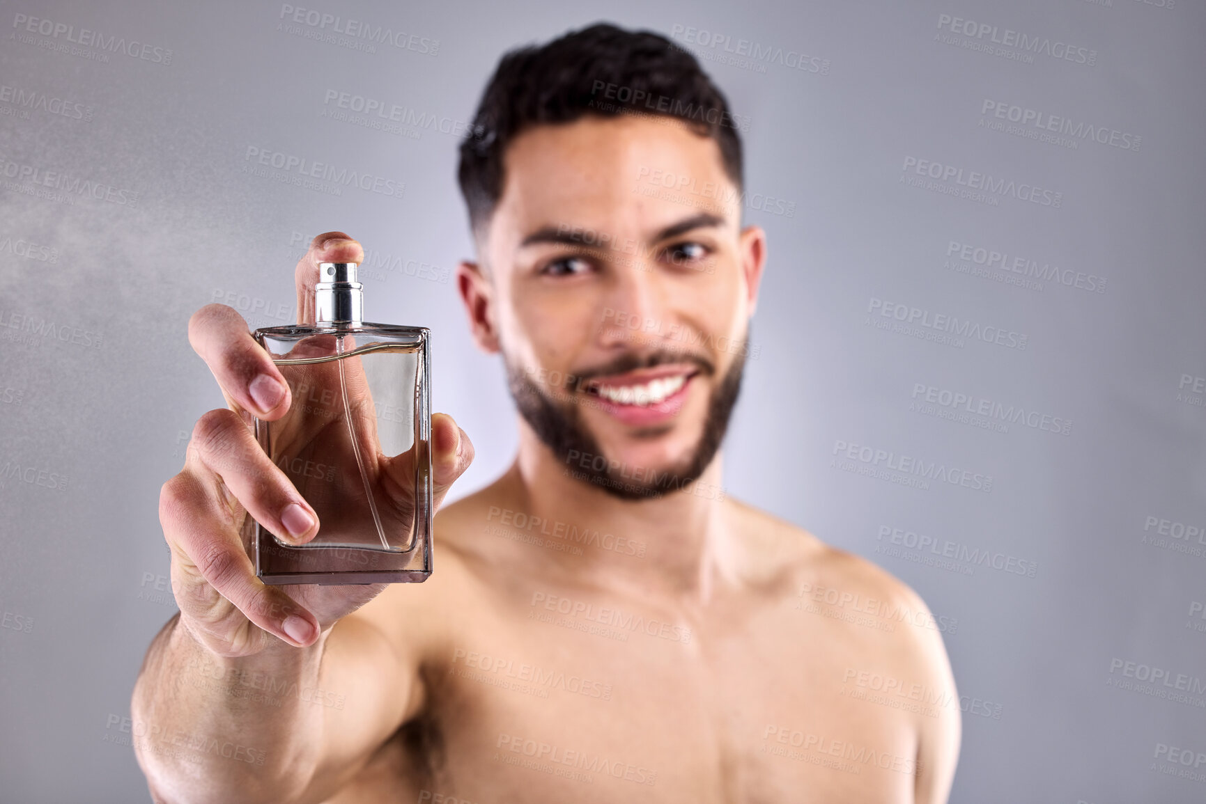 Buy stock photo Man, studio and holding perfume in portrait for luxury cosmetics, smile and spray for scent. Aesthetic, gray background and male person with cologne for wellness, shirtless with glass container